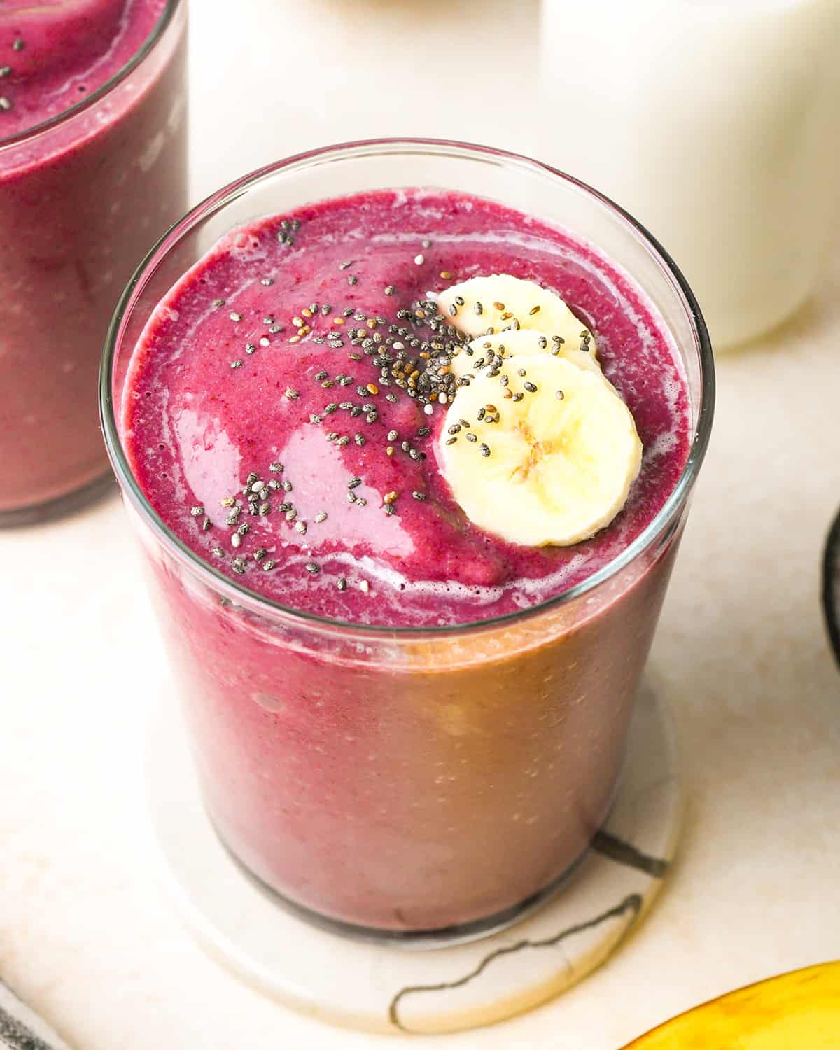 overhead view of a Cherry Smoothie in a glass with chia seeds and banana on top