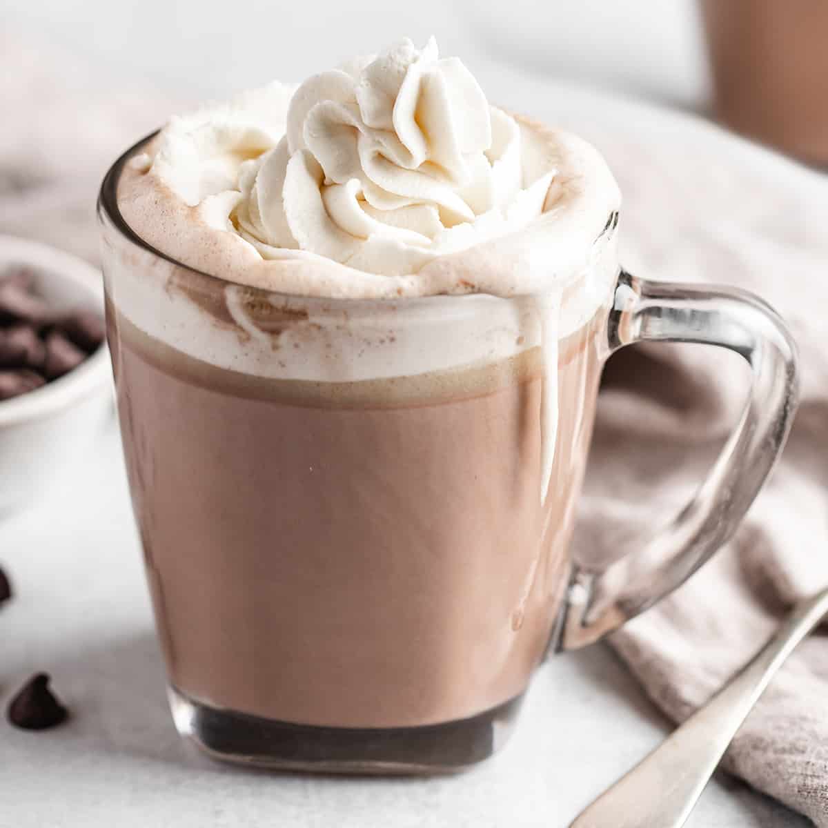 a glass mug full of Crock pot Hot Chocolate topped with whipped cream