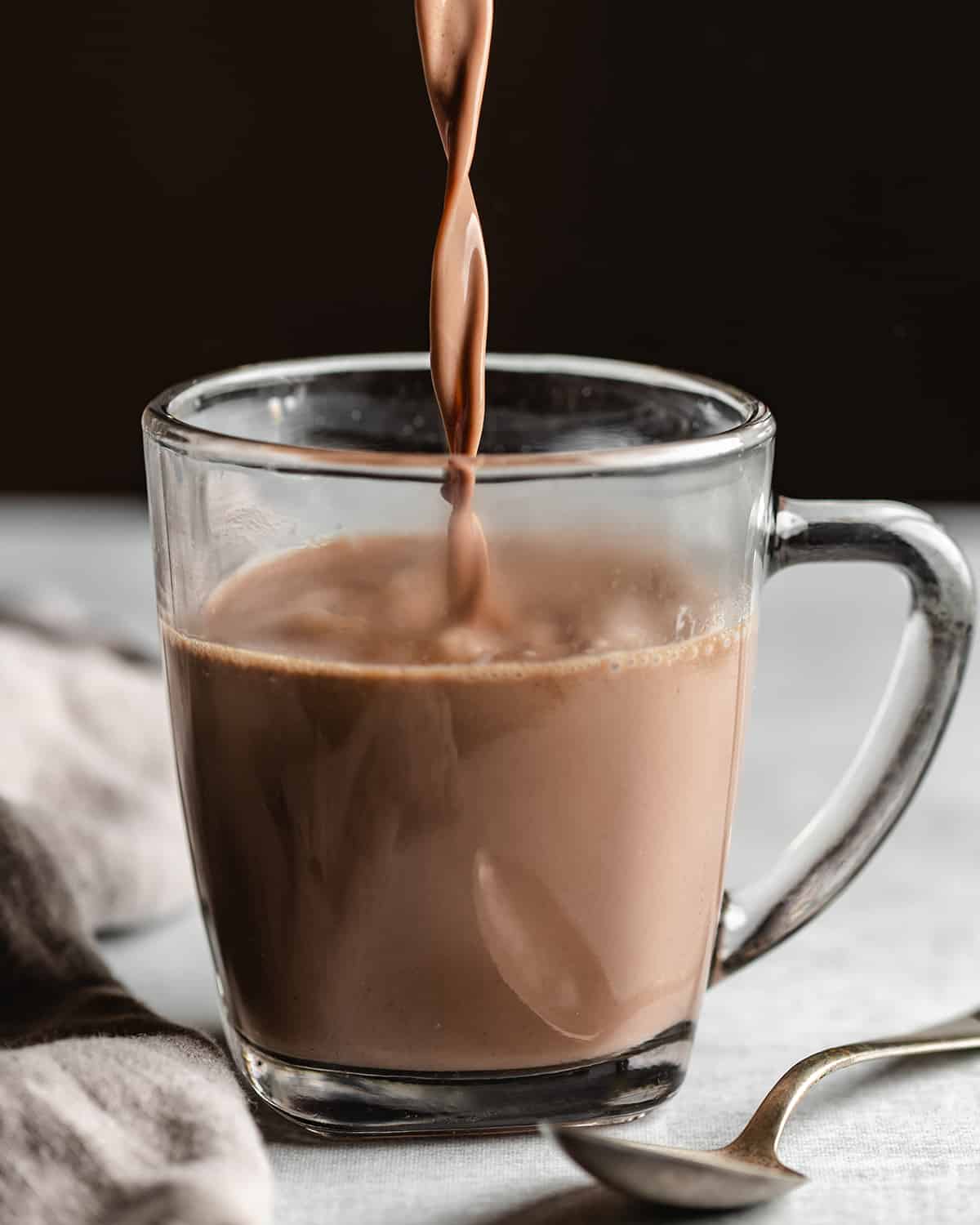 Crock pot Hot Chocolate being poured into a glass mug