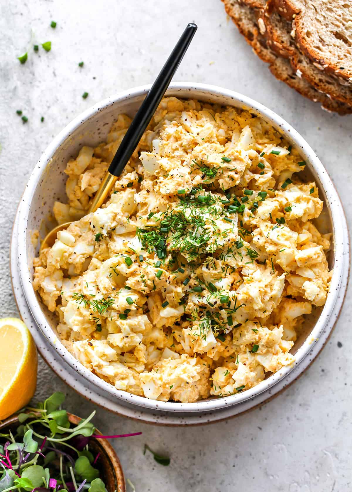 Egg Salad Recipe in a bowl garnished with herbs