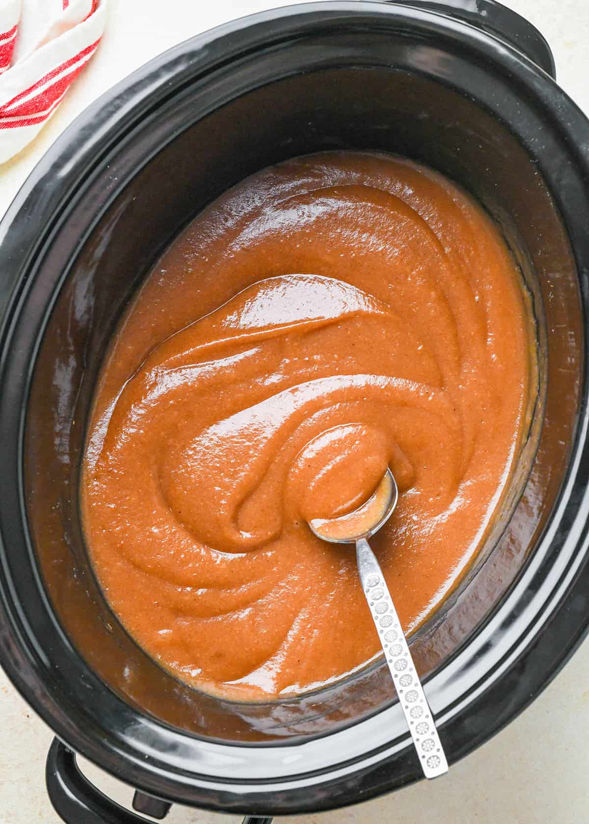 apple butter cooking in a crockpot, uncovered to thicken