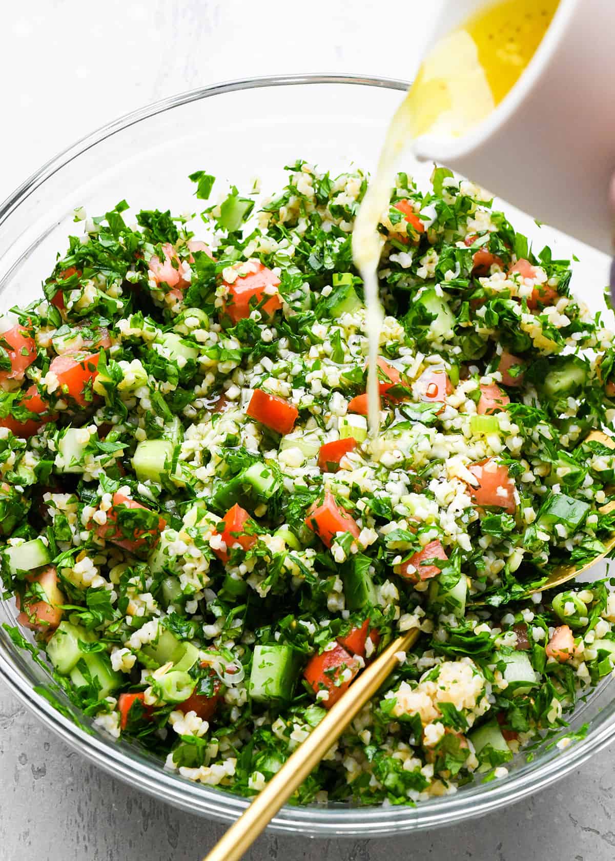 How to Make Tabouli - pouring dressing over the tabouli 