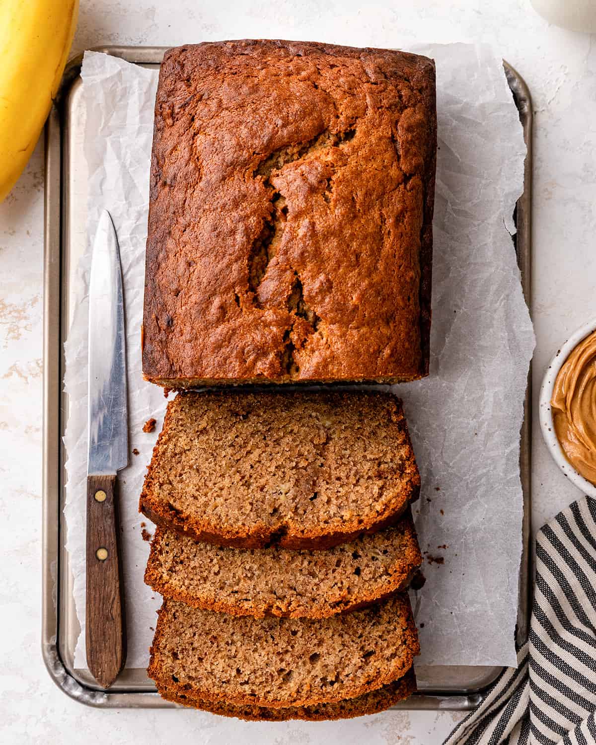 overhead view of a loaf of Peanut Butter Banana Bread with 3 slices cut out