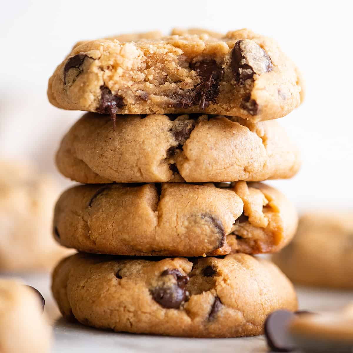 a stack of 4 Peanut Butter Chocolate Chip Cookies, the top one has a bite taken out of it
