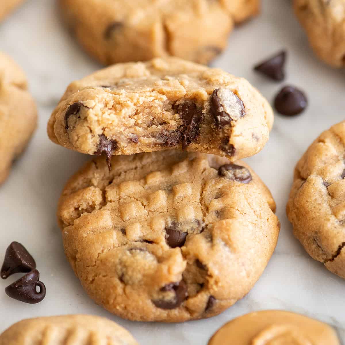 two Peanut Butter Chocolate Chip Cookies, one with a bite taken out of it 