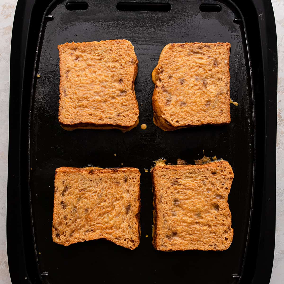 4 pieces of Pumpkin French Toast cooking on an electric griddle